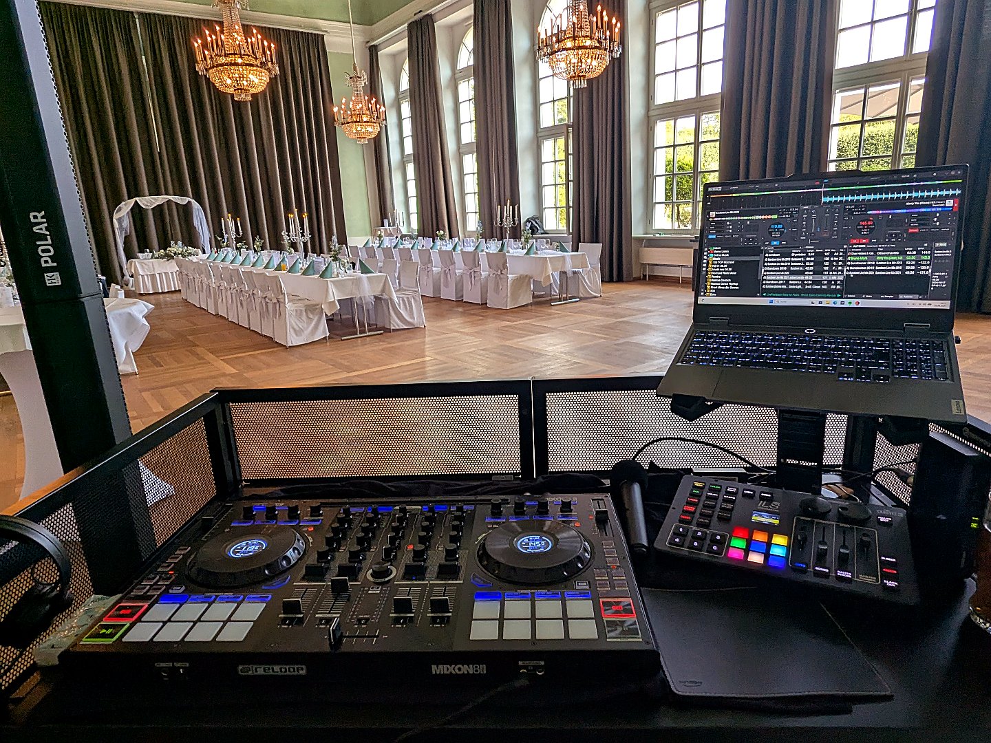 DJ-Pult in einem eleganten Ballsaal mit Kronleuchtern, bereit für eine Hochzeitsfeier